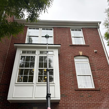 Technician soft washing historic brick home in charlottesville va